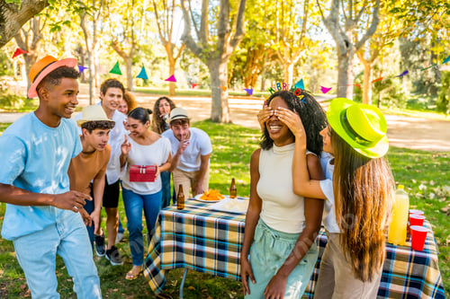 Preview: Friends surprising a woman with birthday gift in a park