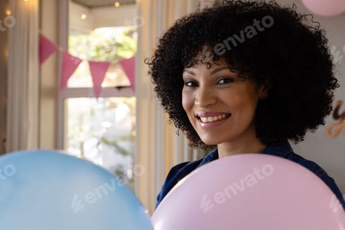 Preview: Holding balloons at home, woman celebrating festive occasion with joy