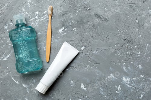Preview: Mouthwash and other oral hygiene products on colored table top view with copy space.