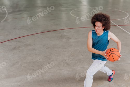 Preview: Young basketball player exercising alone in a court