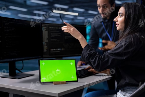 Preview: Colleagues collaborating while working on mockup tablet in data center