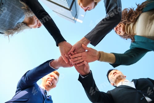 Vista previa: Low angle view of businesspeople stack hands, team building.