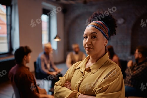 Preview: Mature woman attending a mental health counseling at community center looking at camera.