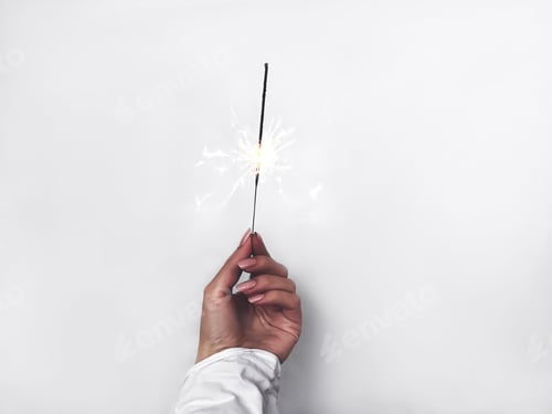 Preview: Hand Holding a Sparkling Light on White Background