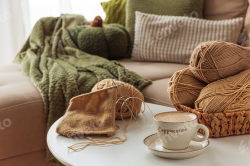 Preview: Cozy Living Room with Yarn, Pumpkins, Pillows and Cup of Cappuccino on White Table