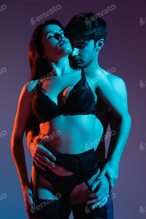 Preview: muscular man hugging sexy girl in lace underwear on purple
