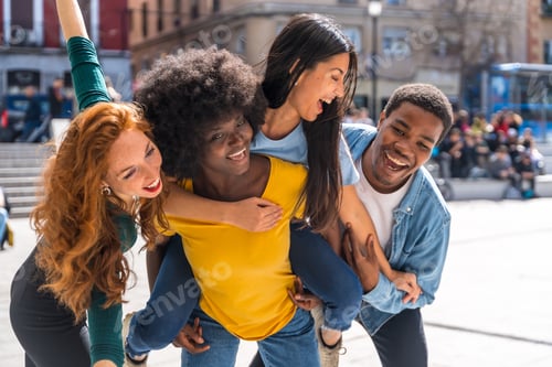 Preview: Happy multiethnic friends in the city with rise on the back and smiling taking a selfie