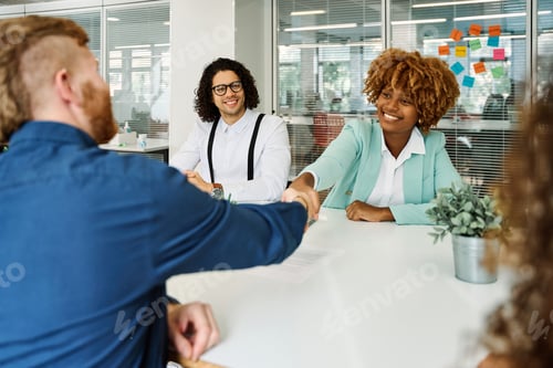 Preview: Multicultural people shaking hands during a meeting in a coworking