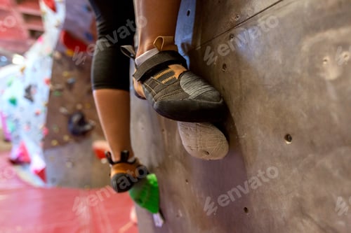 Preview: feet of woman exercising at indoor climbing gym
