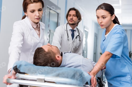 Preview: Doctors and nurse transporting unconscious patient on gurney