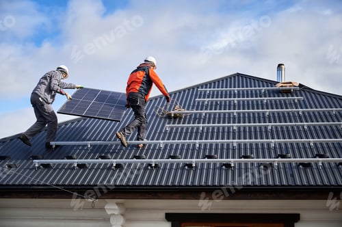 Preview: Workers carrying solar panel on a roof of house