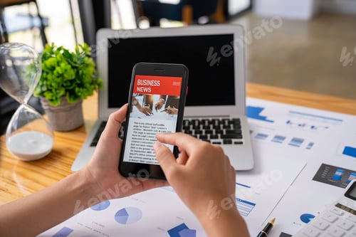 Preview: business woman using a mobile phone in the office to update financial investment news and analysis o