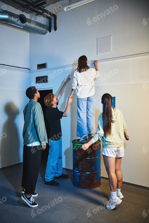 Preview: multicultural men pointing up with fingers while showing clue to female friend standing on barrel