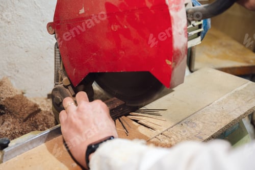 Preview: Cabinetmaker cutting wood with an electric saw at his workshop