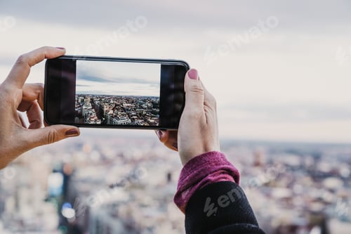 Preview: young photographer woman taking a picture of Madrid city in rooftop. travel,technology and lifestyle