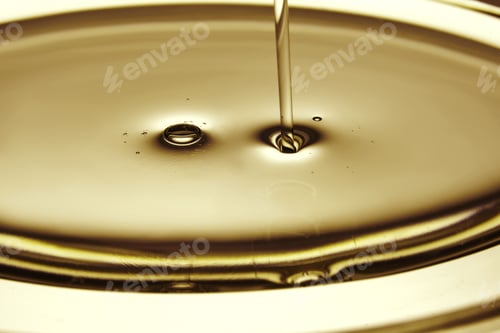 Preview: Pouring oil in golden tones. The texture of a cosmetic or other oil product.