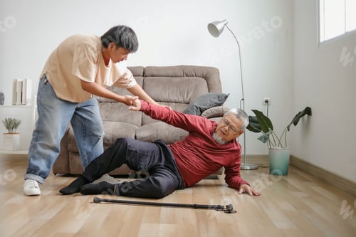 Preview: Young Man Helping His Father After Falling On The Floor At Home