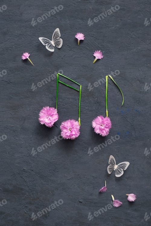 Visualização: Notas feitas de flores e caules em fundo de pedra escura com borboletas