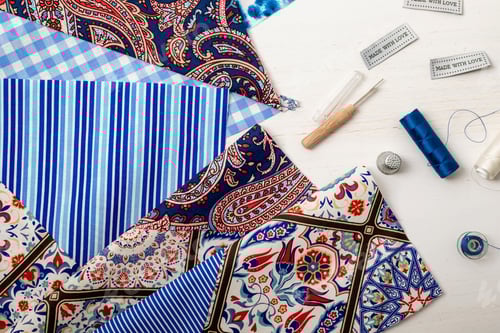 Preview: Fabric and Sewing Accessories Arranged Neatly on Wood