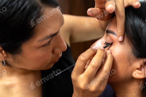 Preview: Makeup artist applying eyeliner on young latina woman
