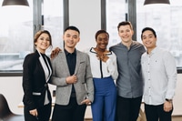 Preview: Group of young businesspeople standing together in office