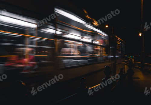 Preview: a person standing on a train platform as it goes by at night