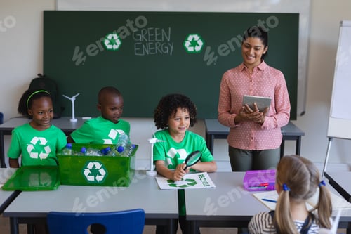 Preview: Schoolkids studying about green energy and recycle at desk in classroom of elementary school