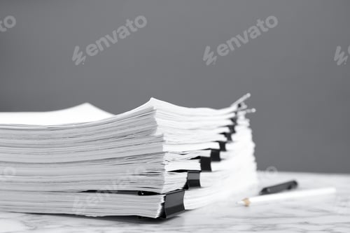 Preview: Stack of documents with binder clips on marble table against grey background