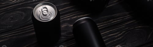 Preview: panoramic shot of black cans of beer on wooden table with copy space