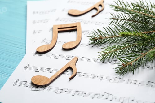 Preview: Christmas tree branch, notes and music sheets on blue wooden table