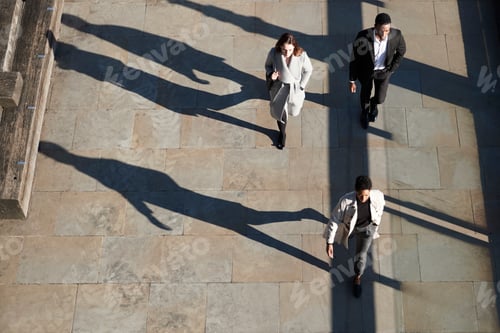 Preview: Aerial view of three city workers walking on a sunny urban street, horizontal
