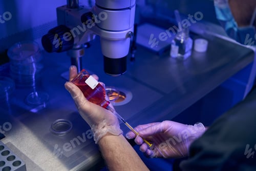 Preview: Laboratory worker taking fluid sample with syringe
