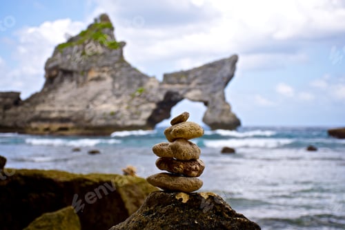 Preview: Pyramid of stones on the background of a rock in the ocean