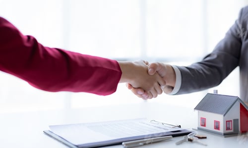 Preview: Real estate agent shakes hands with a client to sign a home purchase contract congratulating