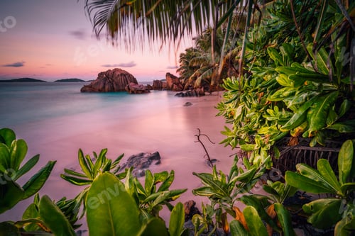 Preview: Beautiful romantic sunset sundown red sky on Seychelles paradise island. Granite rocks, palm trees