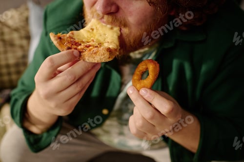 Preview: Man Eating Pizza and Onion Ring at Table