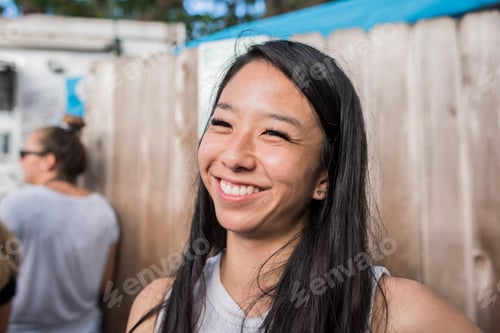 Preview: Smiling woman by wooden fence, Haleiwa, Oahu, Hawaii