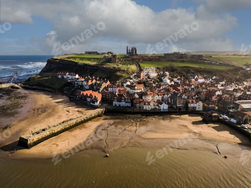 Preview: Aerial shot of Whitby town featuring a serene beach coastline with white sandy shoreline