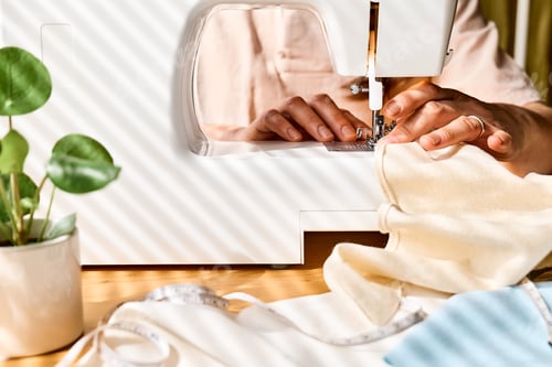 Preview: Seamstress sewing linen fabric on sewing machine in small studio.