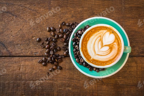 Preview: Top view of hot latte coffee in green cup with latte art and roasted coffee beans on the wooden