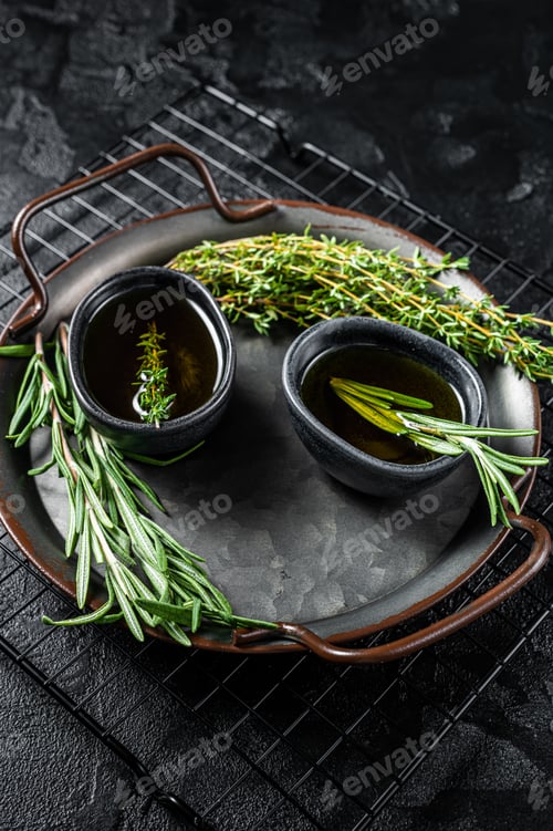 Preview: Assorted fresh herbs with olive oil. Top view. Dark background