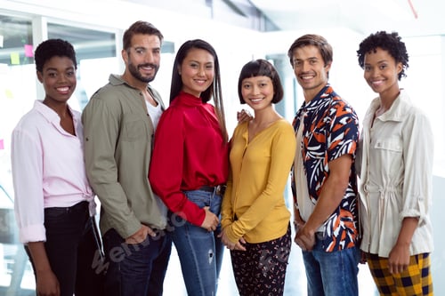Preview: Front view of young diverse business people looking at camera in a modern office