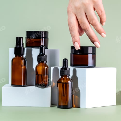 Preview: Female hand touching unbranded amber glass jar with face moisturizing cream. Bottle for professional