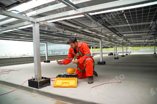 Preview: Technician performing maintenance on solar panels at urban rooftop installation site
