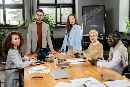 Preview: Group of young contemporary economists looking at you by workplace