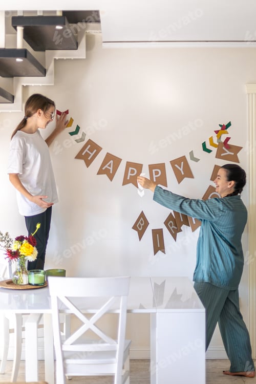 Preview: A mother helps her daughter prepare for her birthday. Birthday concept.