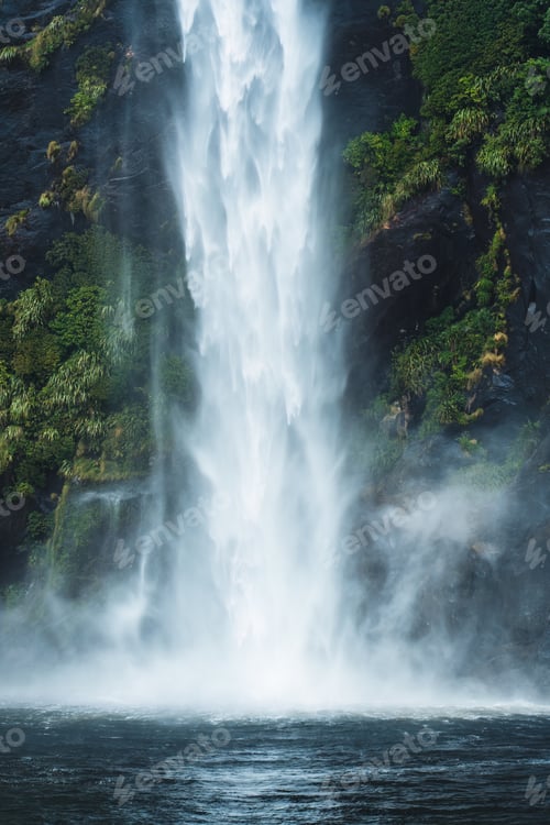 Preview: Moody waterfall flowing in tropical rainforest at Milford Sound