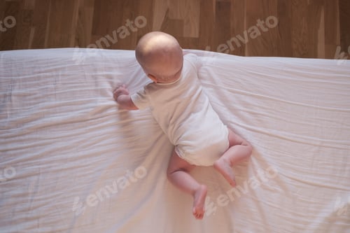 Preview: Caucasian baby crawling to the edge of the bed.