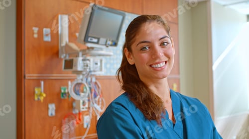 Preview: Portrait Of Female Doctor Or Nurse Wearing Scrubs At Work Standing Beside Hospital Equipment