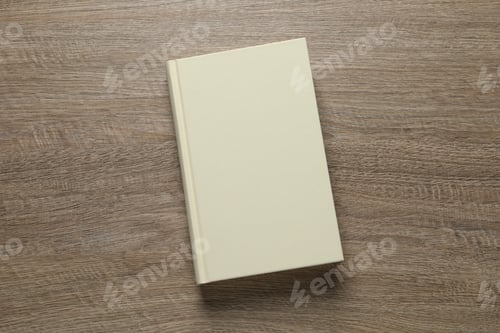 Preview: Closed hardcover book on wooden table, top view